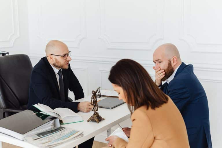 Notaire expliquant assurance vie et succession à un couple d'héritiers