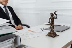 Notaire signant un acte de partage succession sur bureau en bois