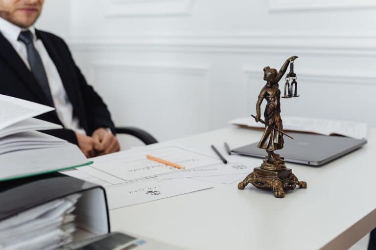 Notaire signant un acte de partage succession sur bureau en bois