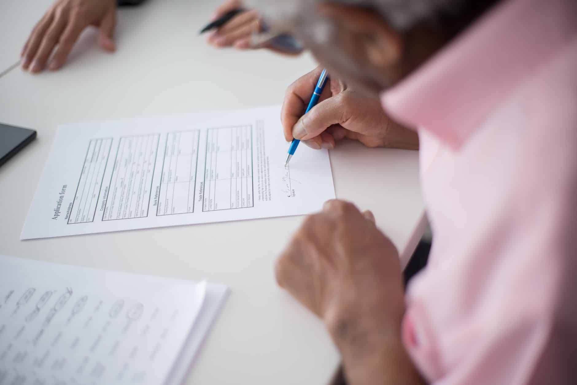 Homme senior signant un acte de révocation testamentaire chez notaire