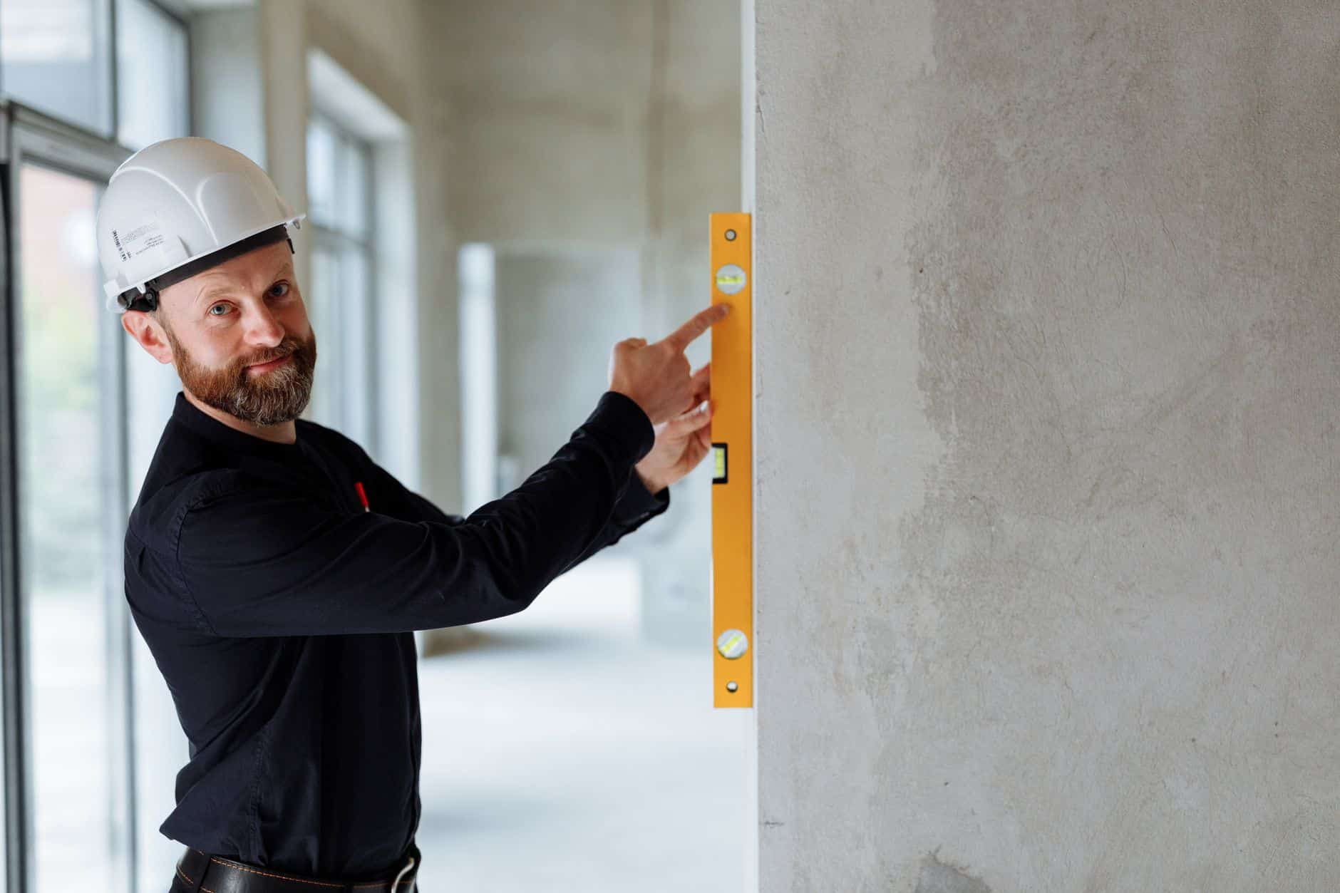 Syndic et artisan inspectant des travaux urgents dans une copropriété française, dégâts visibles
